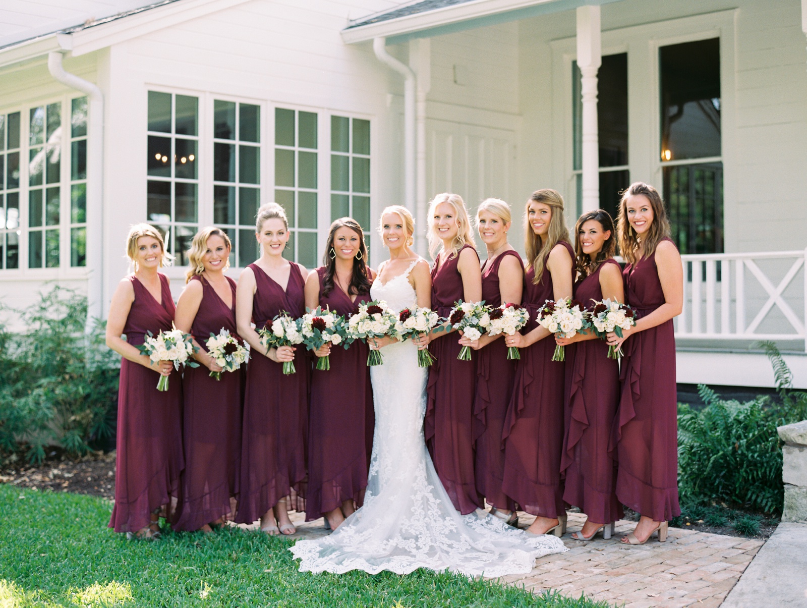 bride and bridesmaids in burgundy, wine with white and greenery bouquets 