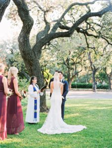 Film Fall wedding in Austin, Texas. Groom is wearing a navy suit, bride is wearing a lace wedding dress.